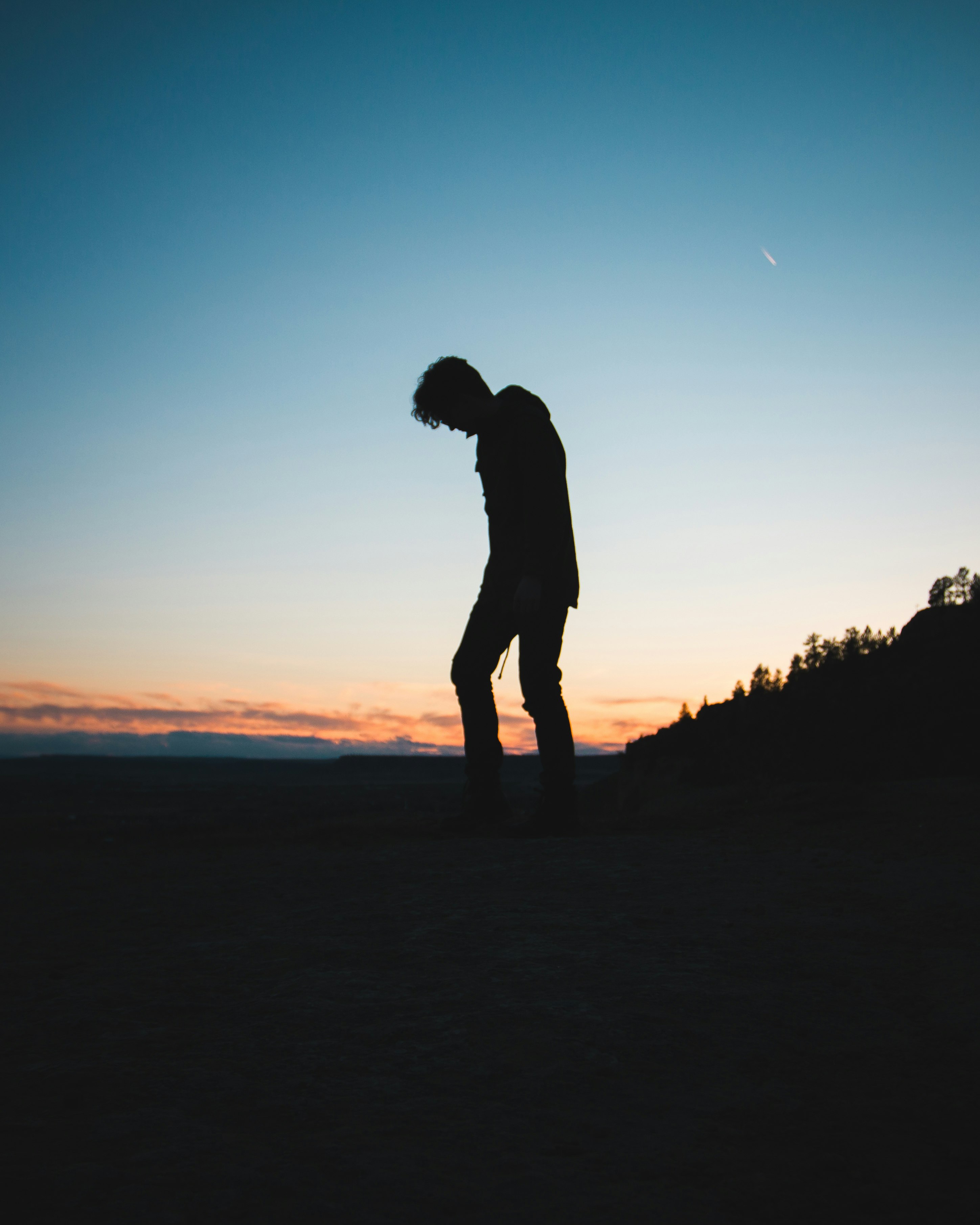 silhouette of man bowing down